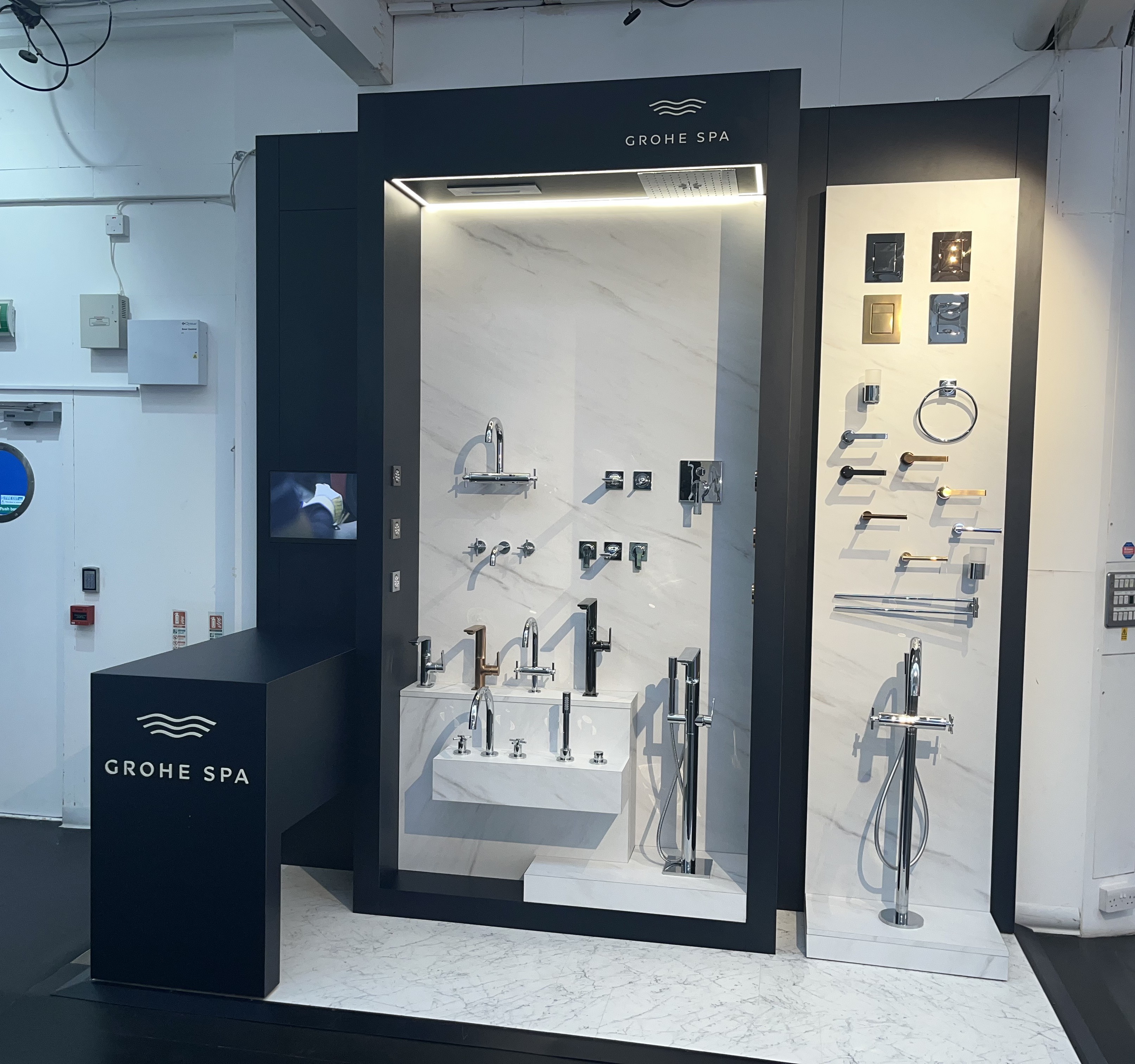 Grohe SPA premium tap and shower display with marble-effect backwall and freestanding basins